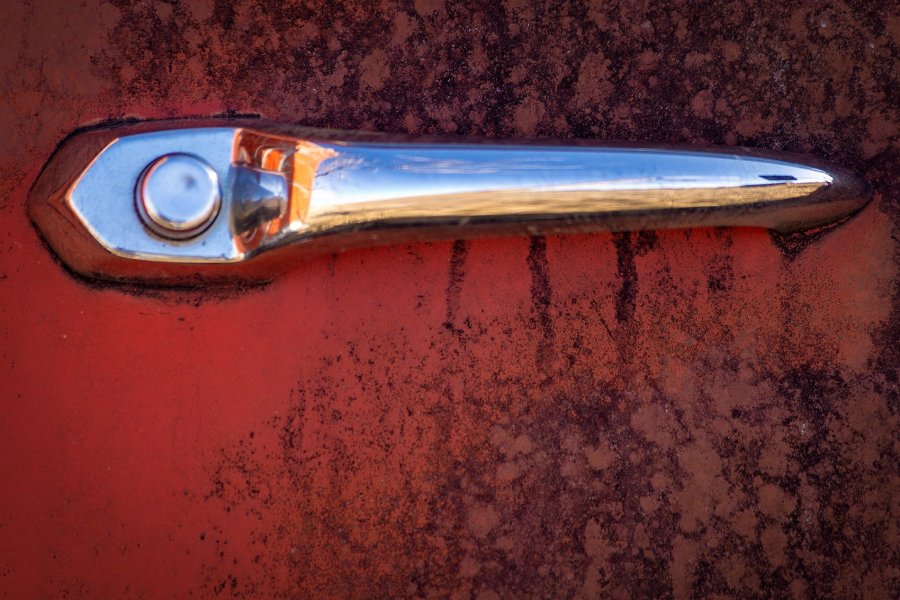 Chrome Door Handle on Rusty Red Door